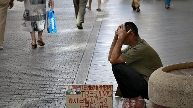 Un indigente pide limosnas en una calle de Sevilla