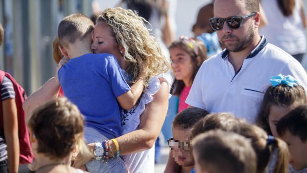Concepción Sierra sostiene en brazos a su hijo a las puertas del colegio en el primer día de clase