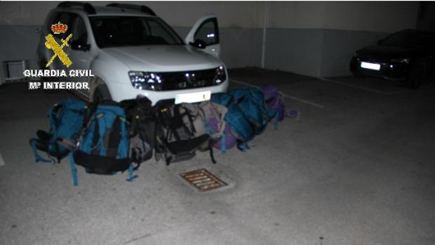 Imagen facilitada por la Guardia Civil del vehículo y de la mochiclas con hachís