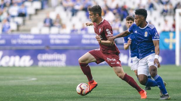 Álex Carbonell conduce el balón perseguido por Yoel Bárcenas en el Real Oviedo-Córdoba CF