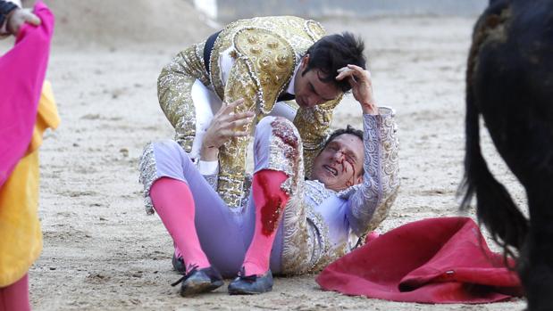 El banderillero, en el suelo, tras la cogida