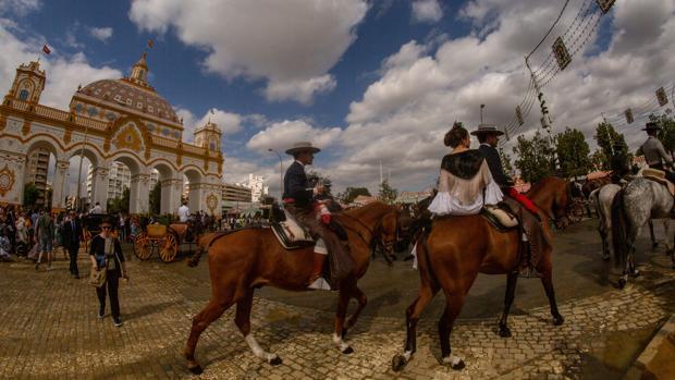 Caballistas en la calle Antonio Bienvenida, ante la portada de Feria