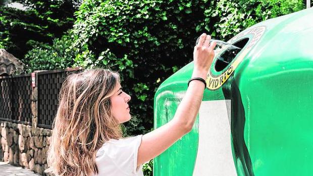 Una joven reciclando vidrio