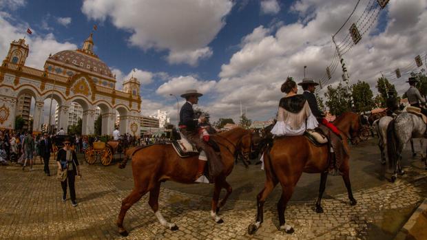 Caballistas en la calle Antonio Bienvenida, ante la portada de Feria